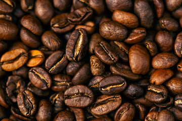 Fototapeta premium close-up on black-blue background lie roasted coffee beans laid out in the shape of a heart 