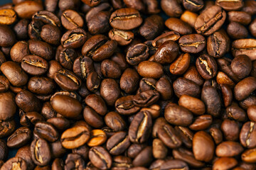 close-up on black-blue background lie roasted coffee beans laid out in the shape of a heart 