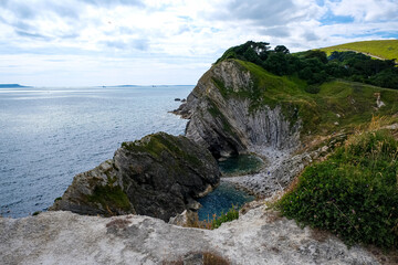 Jurassic coast view in Dorset, England, UK. Stair Hole near Lulworth Cove. Lulworth Cove cliffs view on a way to Durdle Door. The Jurassic Coast is a World Heritage Site on the English Channel coast 