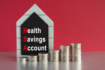 HSA health savings account symbol. Concept words 'HSA' on a black board. Silver coins arranged in a...