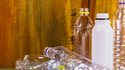 Clear plastic bottles on a wooden surface awaiting recycling.