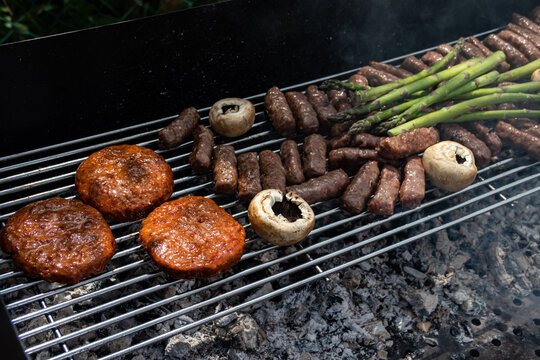 Barbecue patties sausages mushrooms and asparagus on a grill