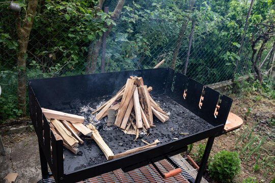 Empty outdoor grill with kindling arranged for a fire