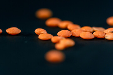 close-up orange lentils close-up lies on black and blue background Ukrainian culture, light protein...