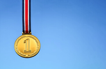 gold medal against a blue background with copy space