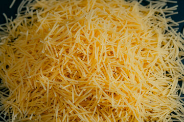 top shot close up yellow thin vermicelli close-up lies on black and blue background Ukrainian culture is the result of flour processing