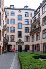 Obraz premium A courtyard with a building in the background. The building has a clock on the front. The courtyard is surrounded by a brick walkway