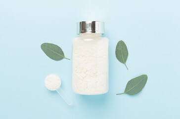 Jars with protein powder on color background, top view. Sports nutrition concept