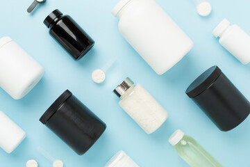 Jars with protein powder on color background, top view. Sports nutrition concept