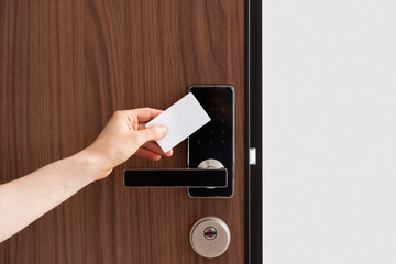 Hand using key card to unlock door in hotel room or apartment