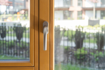 Metal handle on wooden window frame on balcony door
