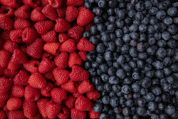 Blueberries and raspberries as a background. Top view.