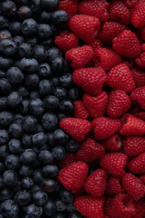Raspberries and blueberries on a plate. Top view. Healthy summer berries.