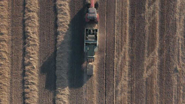 Aerial top down view from a drone Square Hay Bales field with tractor Baler. Small agribusiness, state financial assistance to farmers