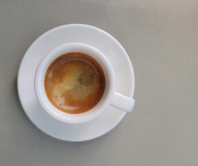 White cup of coffee on the grey background