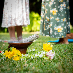 incense lit on the grass during a holistic cleansing session with two women behind