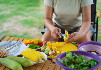 Close-up of asian girl cutting fresh vegetable in bowl.