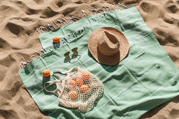 Straw hat, sunglasses, towel, bag on beach sand background. Aesthetic lifestyle, summer vacation...