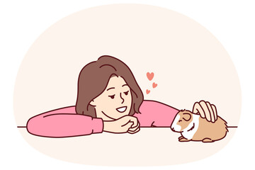 Caring woman pets guinea pig or hamster enjoying companionship of cute pet given to by parents or boyfriend. Young kind girl takes care of guinea pig doing grooming and admiring friendly pet