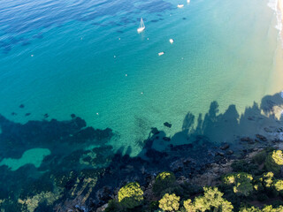 Aerial view on boats, crystal clear blue water of Plage du Debarquement white sandy beach near Cavalaire-sur-Mer and La Croix-Valmer, summer vacation on French Riviera, Var, France