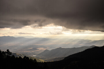 Vista áerea del valle de oaxaca desde las montañas, rayos de luz sobre las montañas en atardecer nuboso 