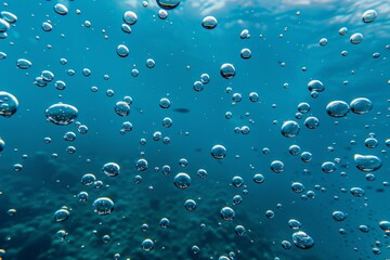 Underwater bubbles floating to the surface in a clear blue ocean