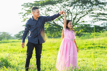 latin father looking at his little brunette daughter with pride, as she turns her body he holds her hand