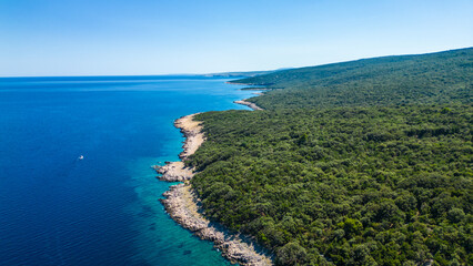 An aerial view of the Blue Lagoon at Plaža Krušćica and Tarej Beach on the island of Cres, showcasing their fantastic turquoise waters and surrounding islands. Boats dot the serene lagoon