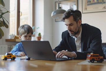 Fototapeta premium Businessman is working from home at his laptop while his son is playing next to him