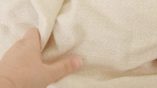 female Hand touching cotton, linen cloth, Seamstress tests texture, checking tactile and functional properties, sewing material, seamstress at work