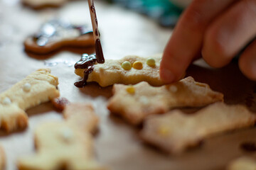 Child's hand decorating cookies