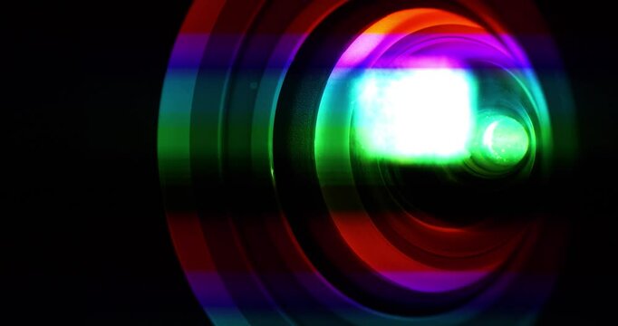 Spectral decomposition of light. Projector lens in operation. Dispersion - decomposition of light into spectral colors