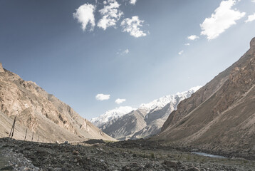 Panorama of mountain range of rocks with snow and glaciers in Pamir in Tajikistan mountains in cloudy weather, minimalistic landscape of high mountains for background