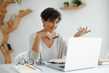 Smiling freelancer having video call on laptop at home