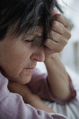 Fototapeta premium Portrait of depressed mature woman lying on bed