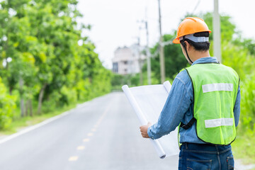 Obraz premium Engineer male road construction working with blueprint. finished asphalt road worker inspector check quality.