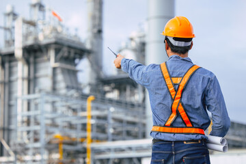 Petroleum Refinery industry engineer male working against oil and gas power industrial factory. Petrochemical power plant industry professional worker.