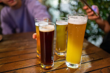The beers have just been brought to the table, the evening with friends begins. One has stretched out his arm to grab a glass. Friendship, conviviality, joy of life.