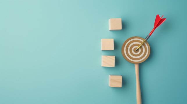 Red dart hitting a bullseye on a target with three wooden cubes on a blue background symbolizing focus, precision, and achievement.
