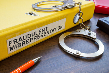 Fraudulent misrepresentation concept. A yellow folder with papers and handcuffs.