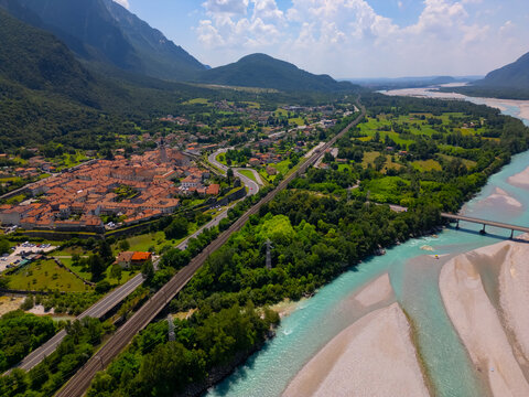 Aerial view of Venzone town, Tagliamenyo river and Alps mountains. Summer nature background with river and mountains. North of Italy