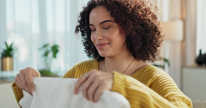 Woman, smell laundry and basket to fold clothes in home, hygiene and fresh linen aroma. Female person, breathe and housework tasks or sanitary, check fabric and cleaner or maid for fragrance scent