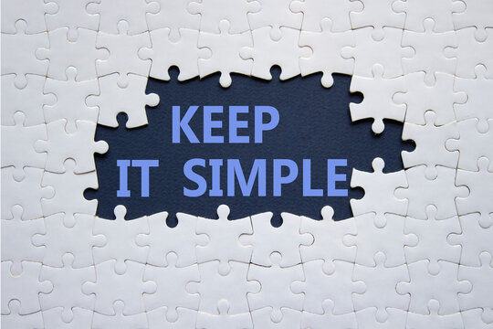 Keep it Simple symbol. Concept words Keep it Simple on white puzzle. Beautiful deep blue background. Business and Keep it Simple concept. Copy space.