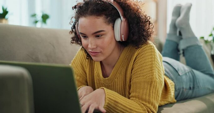 Girl, laptop and headphones on couch in home with smile, listen and relax with subscription in living room. Woman, person and happy on computer, streaming or search for song at apartment in Colombia