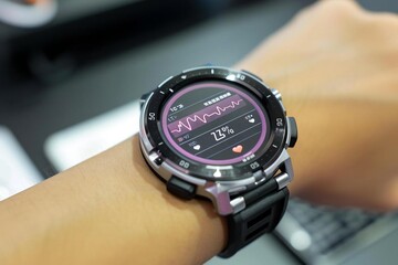 Fototapeta premium close-up shot of a person's hand wearing a smartwatch that shows their heartbeat rate on the digital screen.