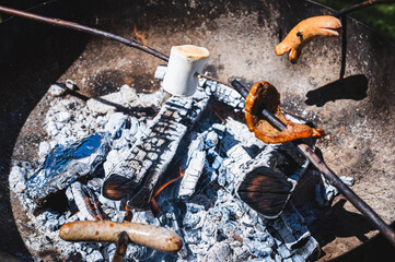 Barbecue on fire. Cervelats, sausages and marshmallow heating above the campfire in Switzerland.