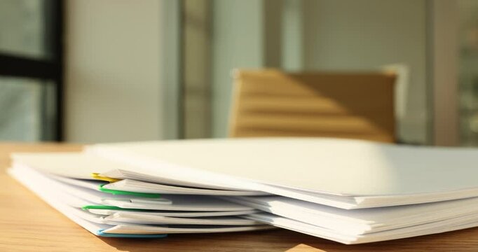 Taking papers connected with paperclips from high pile on table time lapse. Documents and reports in company office. Paperwork organization strategy
