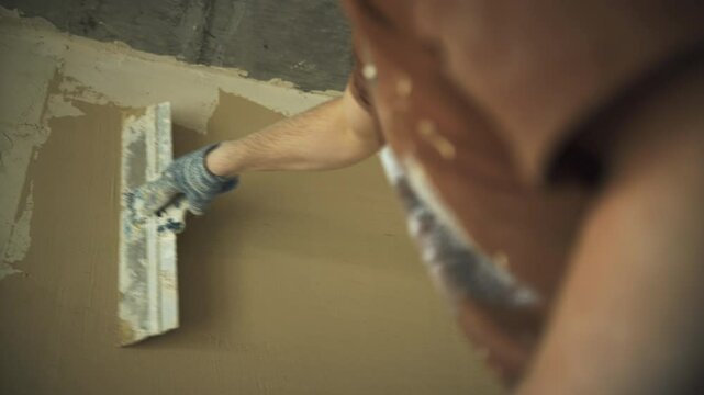 process of plastering a wall with a spatula