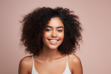 Fototapeta premium portrait of a beautiful woman with curly hair smiling and happy over light pink background