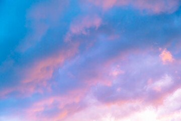 Obraz premium Blue morning sky is in pink clouds. Sunrise clouds are in vanilla colours. Beauty in nature. Twilight time, golden hour. Details of evening sunset. Natural abstraction. Peace concept. Panoramic view
